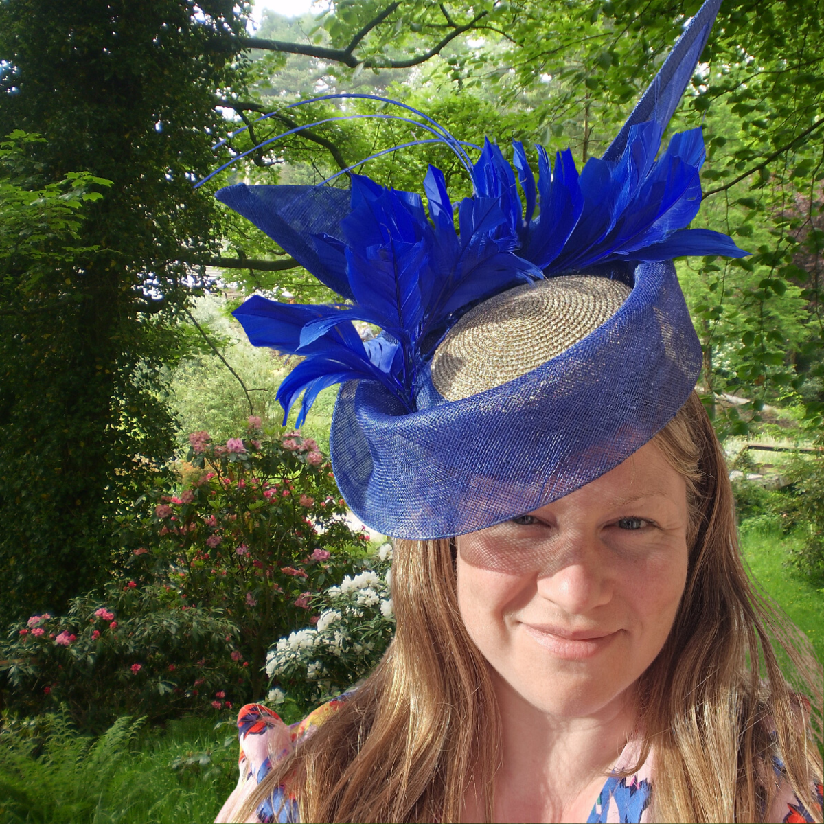 Lady at a garden party, wearing a uniquely designed and made royal blue and gold hat